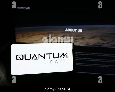 Stuttgart, Deutschland, 19.02.2024: Person, die ein Mobiltelefon mit dem Logo des amerikanischen Luftfahrtunternehmens Quantum Space LLC vor der Business-Webseite hält. Stockfoto