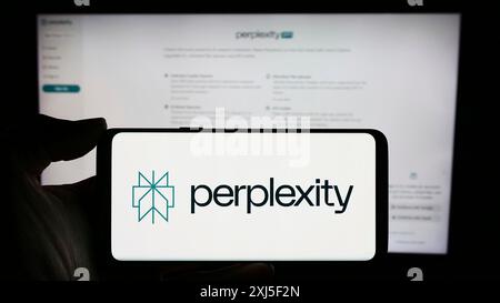 Stuttgart, Deutschland, 16.02.2024: Person, die ein Mobiltelefon mit Logo des US-amerikanischen Künstlichen Intelligenz-Unternehmens Perplexity AI vor der Business-Webseite hält. Stockfoto