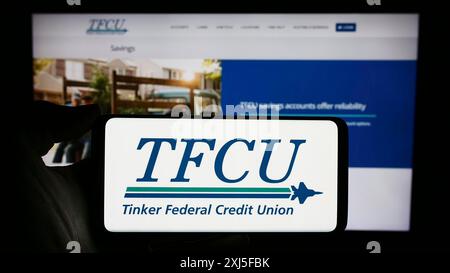 Stuttgart, 22.02.2024: Person mit Mobiltelefon mit Logo der amerikanischen Finanzgesellschaft Tinker Federal Credit Union (TFCU) vor Stockfoto