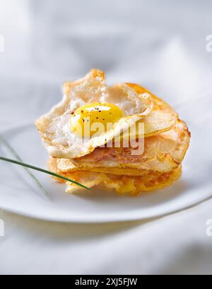 Mille-feuille aus Kartoffelchips mit Pancetta und Wachteleiern (Thema: Mille-feuille Stockfoto