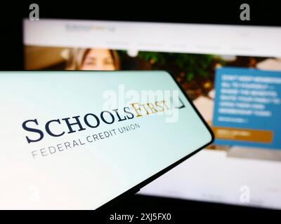 Stuttgart, 23.02.2024: Mobiltelefon mit Logo der amerikanischen Finanzgesellschaft SchoolsFirst Federal Credit Union vor der Website. Konzentrieren Sie sich auf Stockfoto