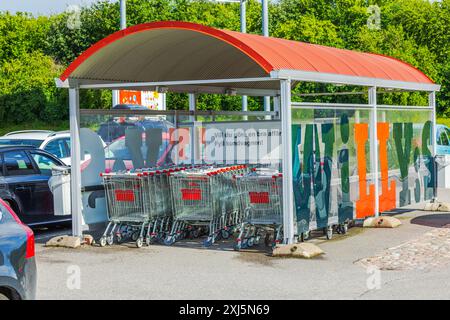 Nahansicht des Parkplatzes in der Nähe des Hypermarktes mit Parkplatz mit Vordach für Einkaufswagen. Stockfoto