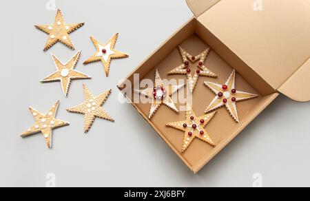 Milchzucker-Kekse. Handgemachte Weihnachtskekse mit gemalten Mustern. Preiselbeeren zur Dekoration. Sternform. Karton zur Verpackung Stockfoto