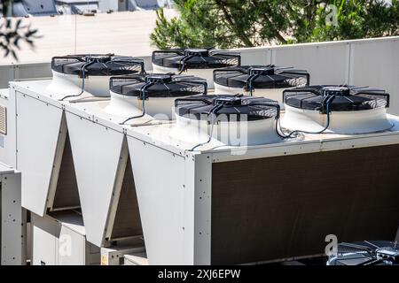 Kommerzielles HLK-System mit mehreren Klimaanlagen auf einem Dach, das externe Komponenten und Kanäle anzeigt, geeignet für Industriegebäude Stockfoto