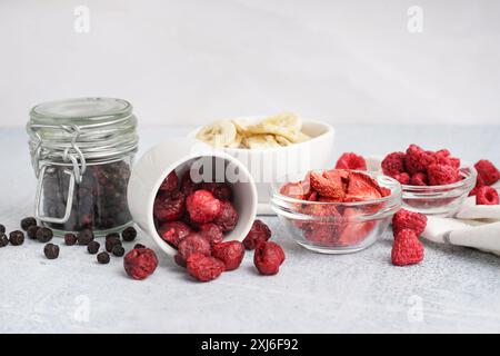 Schüsseln mit verschiedenen gefriergetrockneten Früchten auf hellem Hintergrund Stockfoto