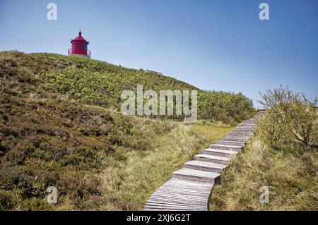 Holzsteg durch die Sanddünen führt zu einem Leuchtturm, Amrum, Nordfriesland, Nordfriesland, Nordfriesland, Schleswig-Holstein, Deutschland Stockfoto