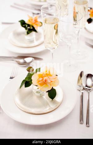 Tabelle-Präsentation mit Glas Crémant und Rosen Stockfoto