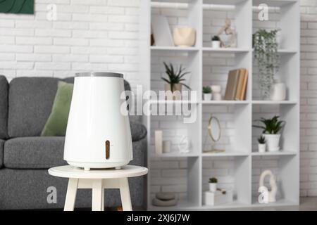 Schwarzes Sofa und moderner Luftbefeuchter auf Couchtisch im Wohnzimmer Stockfoto