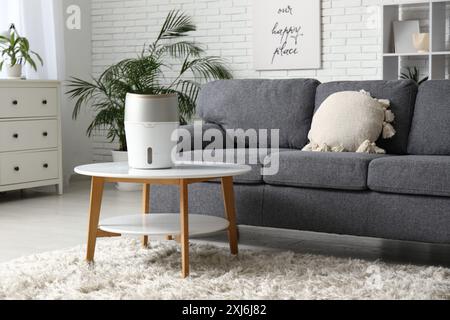 Moderner Luftbefeuchter auf Couchtisch und Kommode im Wohnzimmer Stockfoto