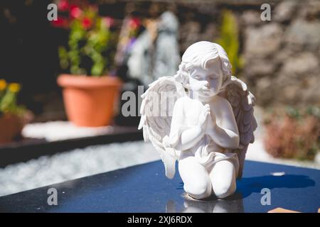 Nahaufnahme einer Statue des weißen betenden Engels auf einem Grab auf einem spanischen Friedhof, Spanien Stockfoto