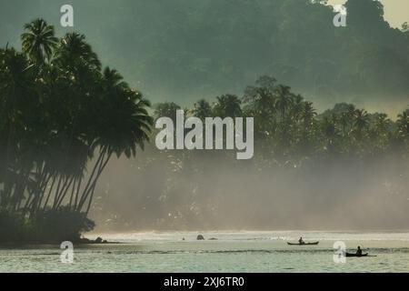 Silhouette von zwei traditionellen sumatranischen Fischern, die am Morgen segeln, Sumatra, Indonesien Stockfoto