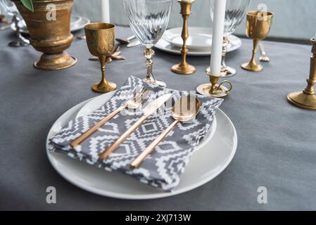 Nahaufnahme Blick auf rustikalen Tisch mit altmodischen Besteck und Serviette auf Platten, Kerzen und leere Weingläser auf der Oberfläche Stockfoto
