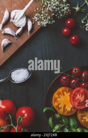 Blick von oben auf die verschiedenen Tomaten, Knoblauch und Salz auf hölzernen Tischplatte mit Kopie Raum Stockfoto