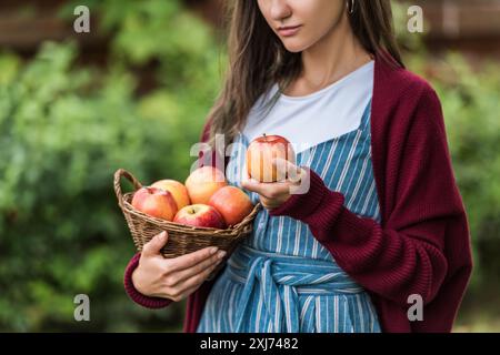 Teilweise mit Blick auf die Mädchen, dass Weidenkorb mit frischen Äpfeln Stockfoto