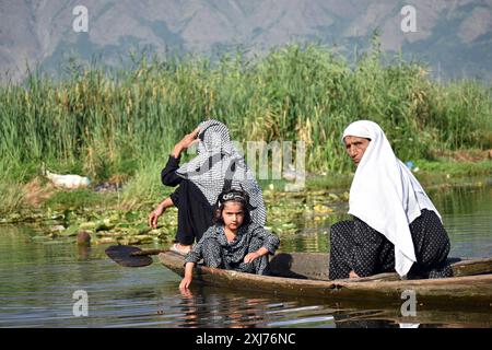 Srinagar, Indien. Juli 2024. Srinagar, Kaschmir, Indien, am 16. Juli 2024: Kaschmirische schiitische Frauen beobachten und sitzen in einem hölzernen Boot, während sie die Muharram-Prozession im ruhigen Inneren des Dal Lake, Srinagar, beobachten. Die Praxis der 9. Muharram-Prozession auf Shikaras im Dal-See, Srinagar, geht auf die Dogra-Ära zurück. Diese verehrte Tradition ist ein integraler Bestandteil der kaschmirischen Kultur, die Muharram feiert und dem Martyrium von Imam Hussain Tribut zollt. Foto: Danish Showkat/SIPA USA. Quelle: SIPA USA/Alamy Live News Stockfoto