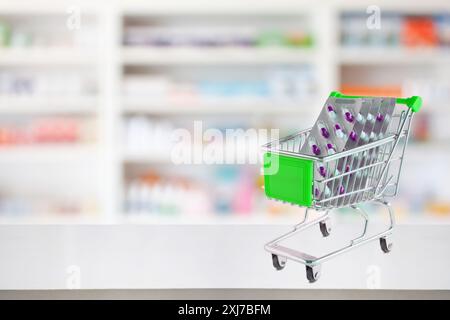 Medizin Pillen Blister Pack Kapsel im Warenkorb auf Apotheke Ladentisch mit unscharfen Drogerie Regalen defokussierten Hintergrund Stockfoto