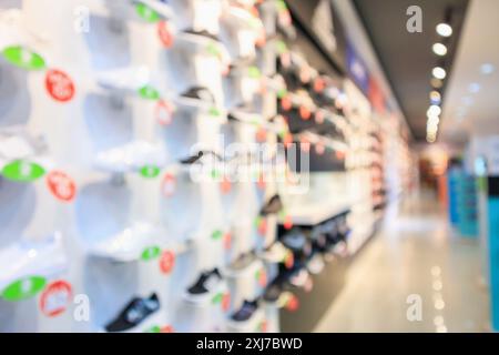 Sneakers werden in Regalen im Sportschuhgeschäft präsentiert und zeigen abstrakten, verschwommenen Hintergrund Stockfoto