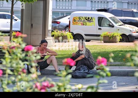 Nicht exklusiv: ODESA, UKRAINE - 13. JULI 2024 - Ein Mann und eine Frau sitzen an einem heißen Sommertag am Bordstein, Odesa, Süd-Ukraine. Stockfoto