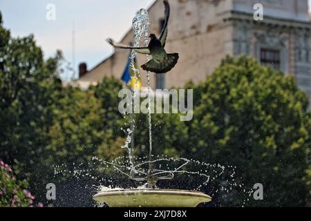 Nicht exklusiv: ODESA, UKRAINE - 13. JULI 2024 - Eine Taube fliegt an einem heißen Sommertag in Odesa, Süd-Ukraine, an einem Brunnen vorbei. Stockfoto