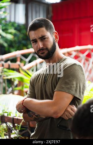 Junger bärtiger Mann, der mit gekreuzten Armen überrascht aussieht. Vertikal Stockfoto