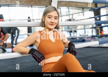 Porträt einer schönen Frau in brauner Fitness-Kleidung, die in einem örtlichen Fitnessstudio ruht Stockfoto