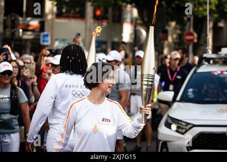 Paris, Frankreich. Juli 2024. Ein olympischer Fackelträger kommt mit der olympischen Fackel am Place Bastille vorbei. Tausende von Menschen füllten die Straßen von Paris, um die olympische Fackel an ihrem zweiten Tag in der französischen Hauptstadt vorbeiziehen zu sehen. Nach einem emotionalen ersten Tag, der mit den Festlichkeiten zum Bastille Day zusammenfiel, reiste die olympische Fackel erneut über den Place de Bastille in Richtung Place de Republique, ihrem endgültigen Ziel. (Foto: Telmo Pinto/SOPA Images/SIPA USA) Credit: SIPA USA/Alamy Live News Stockfoto