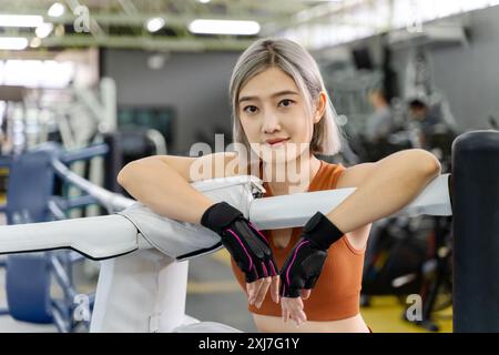 Porträt einer schönen Frau in brauner Fitness-Kleidung, die in einem örtlichen Fitnessstudio ruht Stockfoto