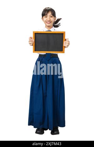 Porträt eines asiatischen Schülers der Junior High School in weiß-blauer Uniform stehend und zeigt leere kleine Tafel isoliert über weißem Hintergrund Stockfoto