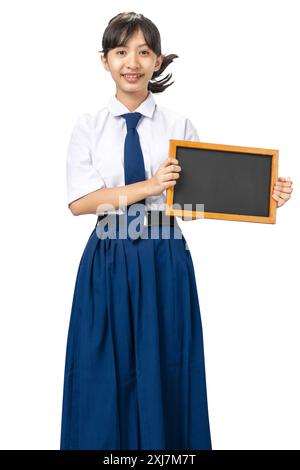 Porträt eines asiatischen Schülers der Junior High School in weiß-blauer Uniform stehend und zeigt leere kleine Tafel isoliert über weißem Hintergrund Stockfoto