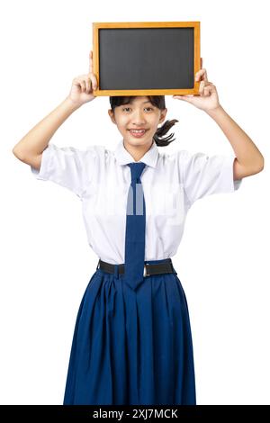 Porträt eines asiatischen Schülers der Junior High School in weiß-blauer Uniform stehend und zeigt leere kleine Tafel isoliert über weißem Hintergrund Stockfoto