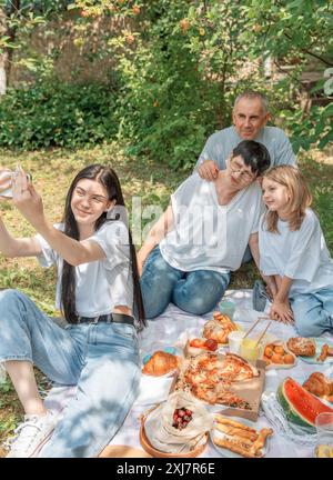 Familie macht Selfie während des Picknicks. Ein Mädchen macht ein Selfie mit ihrer Familie auf ein Picknick Stockfoto