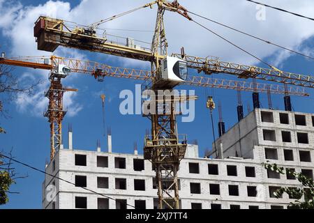CHARKIW, UKRAINE - 12. JULI 2024 - Turmkräne werden auf der Baustelle eines Wohnblocks in Charkiw, Nordostukraine gesehen. Stockfoto