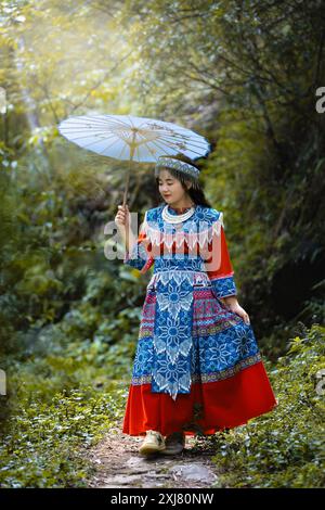 Schöne junge asiatische Frau, die in Nordvietnam Sa Pa traditionelle hmong-Tracht trägt. Vietnamesisches Mädchen in traditioneller Kleidung hält einen Regenschirm Stockfoto