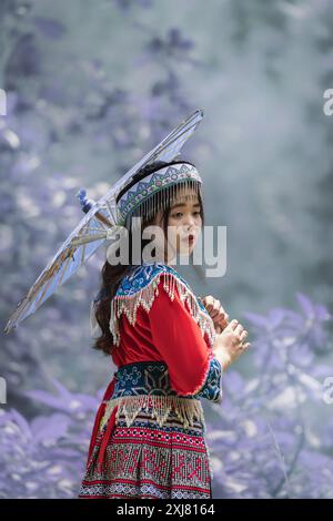 Schöne junge asiatische Frau, die in Nordvietnam Sa Pa traditionelle hmong-Tracht trägt. Vietnamesisches Mädchen in traditioneller Kleidung hält einen Regenschirm Stockfoto