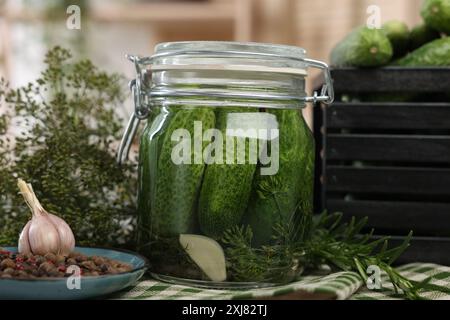 Eingelegte Gurken im Glas, Kräuter und Gewürze auf dem Tisch, Nahaufnahme Stockfoto