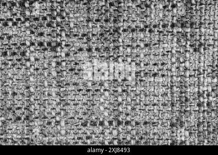Textur des grauen Jacquard-Gewebes aus grobem Makrogewebe, Nahaufnahme. Gemischte Farbe, meliertes Tuch. Material für Heimtextilien, Polster und Vorhangdekor, g Stockfoto