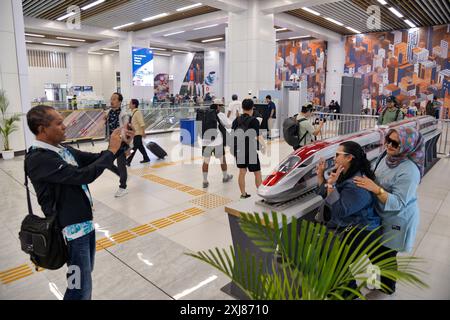 Jakarta, Indonesien. Juli 2024. Passagiere posieren für Fotos mit einem Modell eines elektrischen Hochgeschwindigkeitszugs (EMU) der Hochgeschwindigkeitsbahn Jakarta-Bandung in der Wartehalle des Halim-Bahnhofs in Jakarta, Indonesien, 17. Juli 2024. Die Hochgeschwindigkeitsbahn Jakarta-Bandung (HSR) war am Montag mit über 4 Millionen beförderten Fahrgästen neun Monate in Betrieb, sagte PT Kereta Cepat Indonesia-China (KCIC), ein Joint-Venture-Konsortium zwischen indonesischen und chinesischen Staatsunternehmen, das den HSR baut und betreibt. Quelle: Xu Qin/Xinhua/Alamy Live News Stockfoto