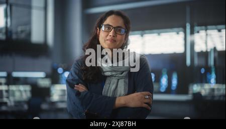 Porträt eines wunderbaren, lächelnden IT-Spezialisten, der für die Kamera im Data Science Laboratory posiert. Junge indische Frau, die in die Kamera schaut. Erfolgreiche Frau, die bei Big Server Farm Cloud Computing Company arbeitet Stockfoto