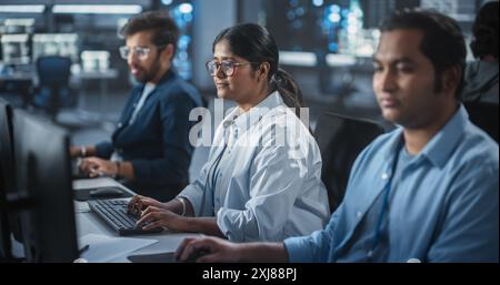 Gruppe von befähigten multikulturellen Männern und Frauen, die in einem Forschungszentrum arbeiten, Computer verwenden, um fortgeschrittene Software auszuführen, künstliche Intelligenz-Schnittstelle und neuronale Netzwerk-Blockchain zu entwickeln Stockfoto