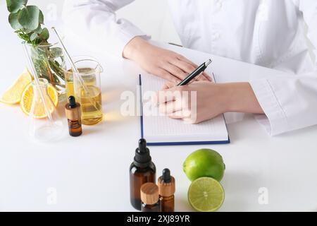 Aromatherapeutikum. Wissenschaftler, der ätherische Öle am weißen Tisch im Labor entwickelt, Nahaufnahme Stockfoto