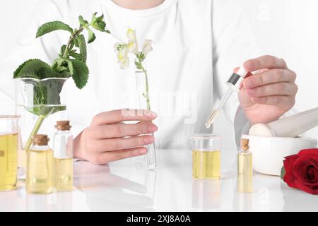 Aromatherapeutikum. Wissenschaftler, der ätherische Öle am weißen Tisch im Labor entwickelt, Nahaufnahme Stockfoto