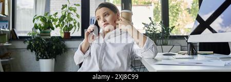 Eine junge Geschäftsfrau mit Behinderung sitzt im Rollstuhl in einem modernen Büro, arbeitet und spricht am Telefon. Stockfoto