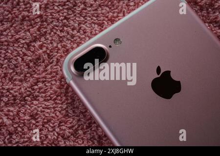 Terengganu, Malaysia - 2. August 2024 : Großaufnahme des rosafarbenen Apfels iphone 7 plus Telefon auf rotem Hintergrund. iphone-Gerät auf der Rückseite. Apple iphone Logo. Stockfoto