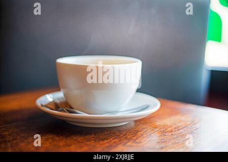 Heißes Getränk Tee oder Kaffee in einer weißen Tasse auf einem Bluetz, guten Morgen Stockfoto