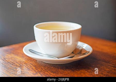 Heißes Getränk Tee oder Kaffee in einer weißen Tasse auf einem Bluetz, guten Morgen Stockfoto