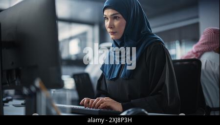 Porträt eines intelligenten Ingenieurs aus dem Nahen Osten, der in einem technologischen Unternehmensbüro am Computer arbeitet. Junge arabische Frau, die Software für einen innovativen Internetdienstanbieter entwickelt Stockfoto