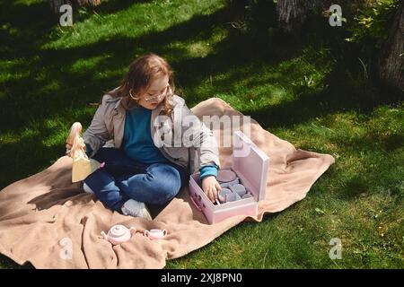 Ein kleines Mädchen mit Down-Syndrom genießt eine Nachmittagstee-Party im Park. Stockfoto