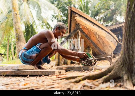 westbengalen – Indien – 20. November 2023: Ein indischer Fischer wird auf seinem traditionellen Holzboot gesehen. Das Konzept der indischen Wirtschaft und des Lebens Stockfoto