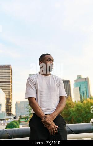 Vertikale Aufnahme eines jungen schwarzen Mannes in Straßenkleidung, der selbstbewusst im Freien unterwegs ist Stockfoto