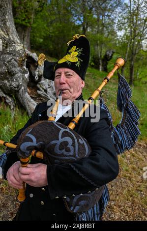 Ein traditioneller Gaiteiro aus Galicien, gekleidet in klassischer Kleidung mit Weste, weißem Hemd, knielanger Hose und breiter Krempe, spielt den Gaita, den legendären Dudelsack der Region. Dieser Musiker verkörpert das reiche kulturelle Erbe und die musikalischen Traditionen Galiciens und bringt lebendige Melodien in die festliche Atmosphäre lokaler Feiern Stockfoto